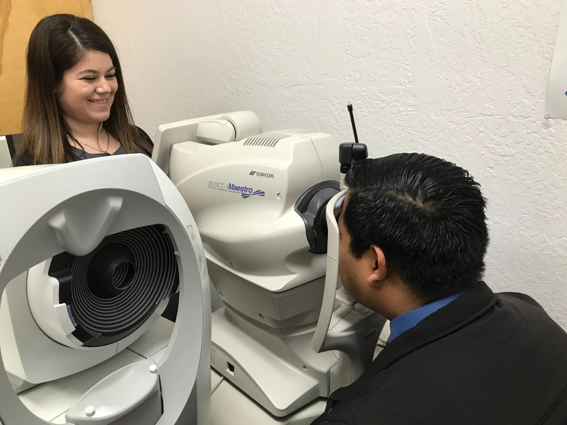 Patient seated at an autorefractor during a comprehensive eye exam